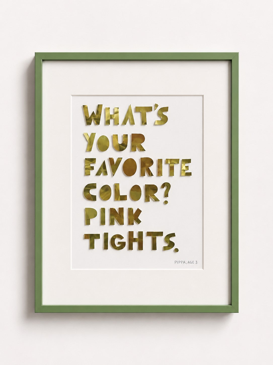 Quote piece in a green frame: gold metal letters reading What's your favorite color? Pink tights.