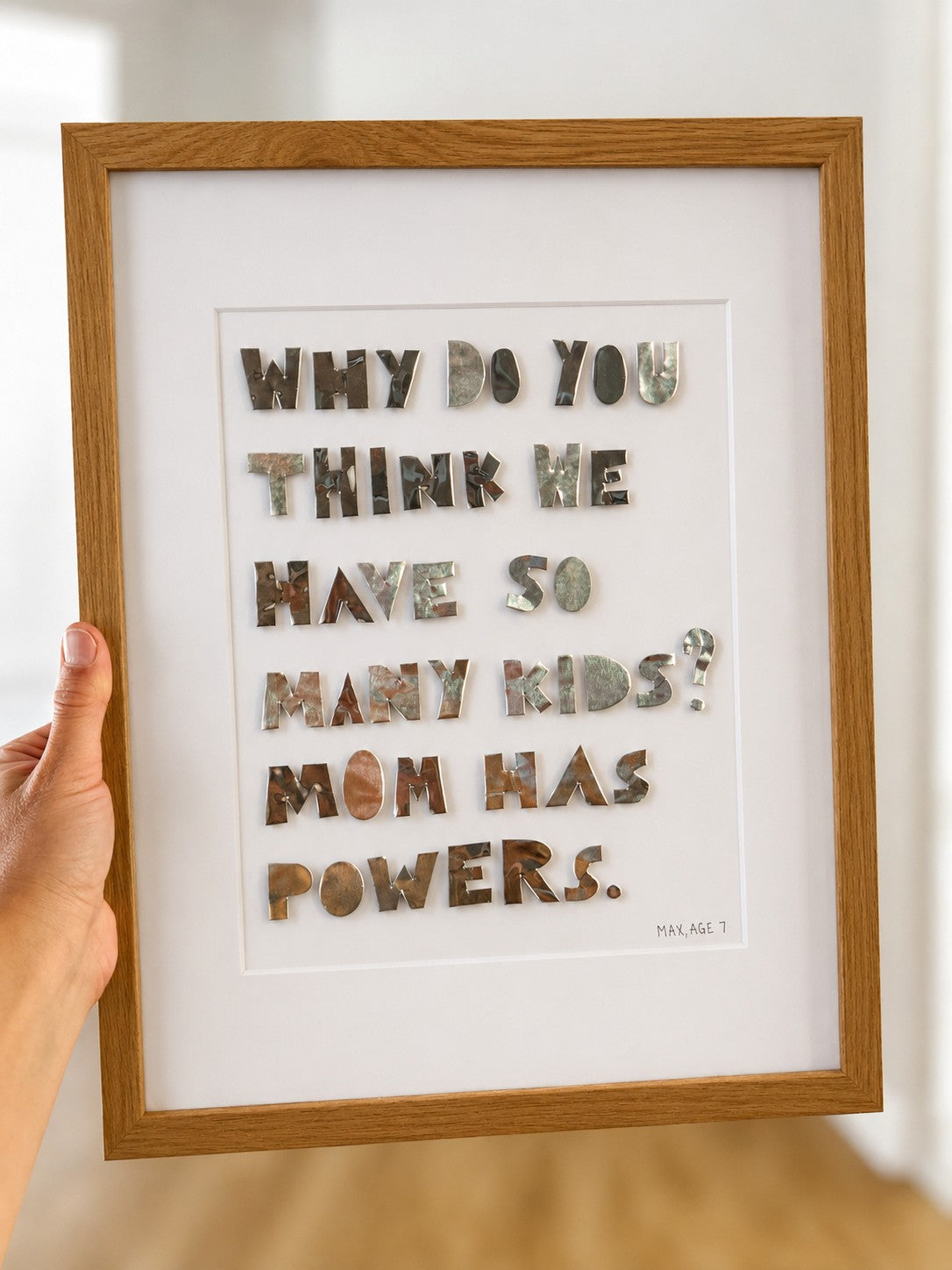 Quote piece in a natural oak frame held up by hand